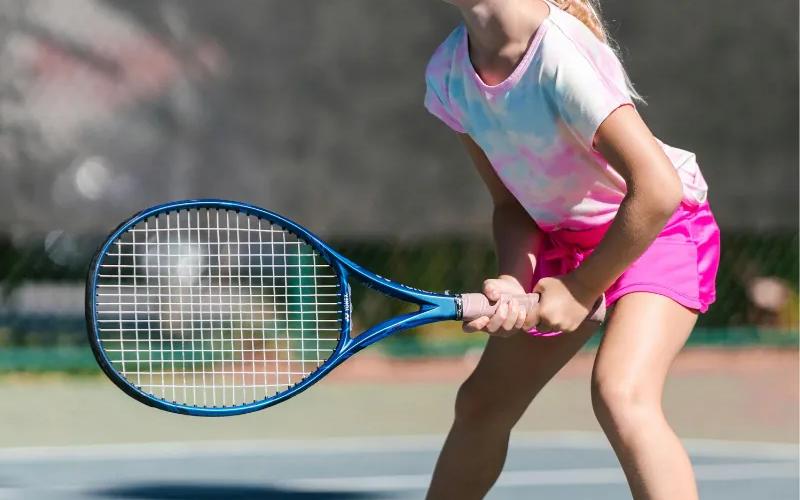 A young tennis player holding a racket on court