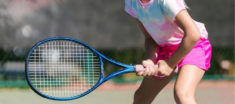 A young tennis player holding a racket on court