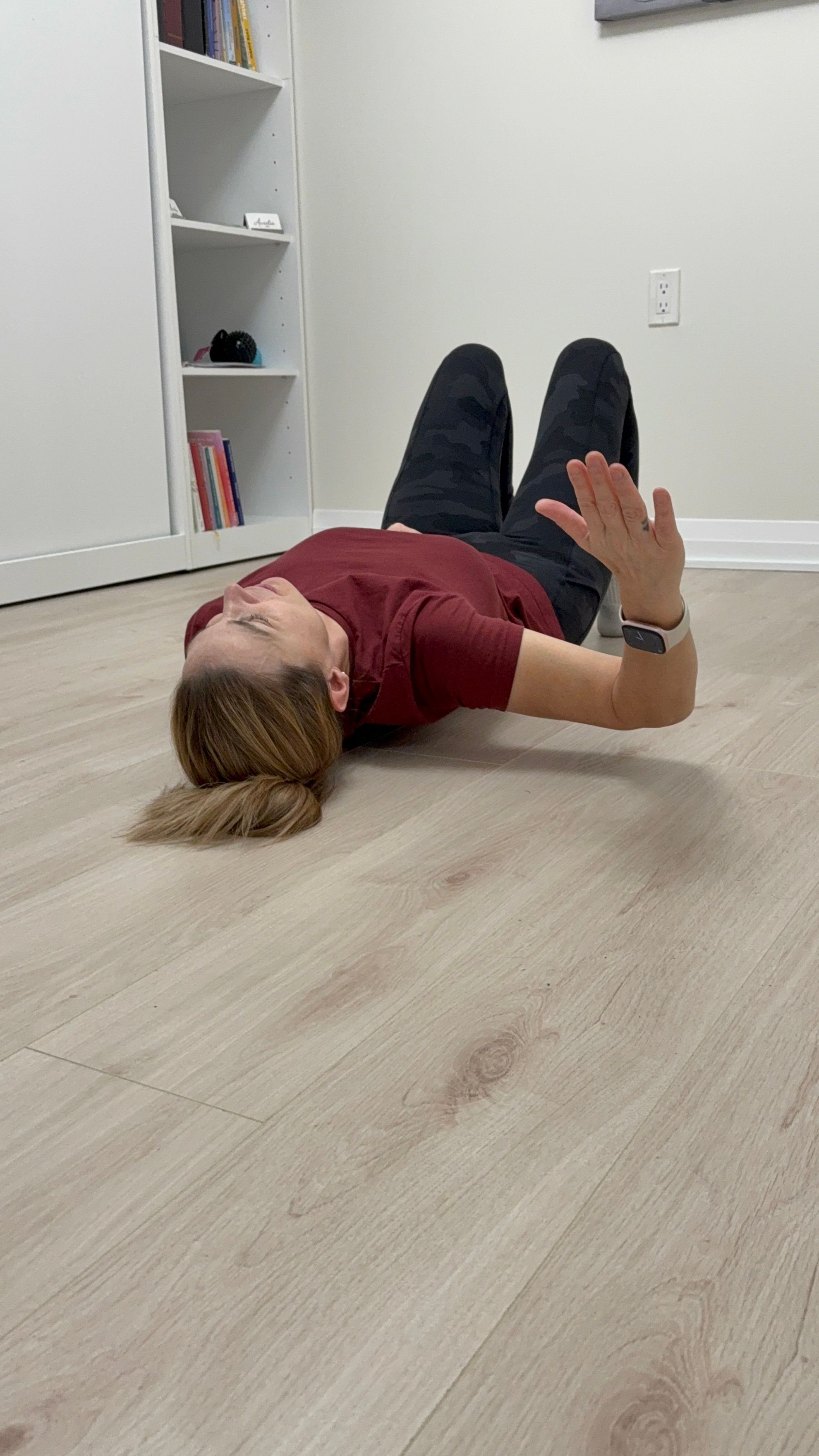 Alt text: Person lying on back with knees bent, using a smooth massage ball under the upper shoulder blade with arm in a 90/90 position.