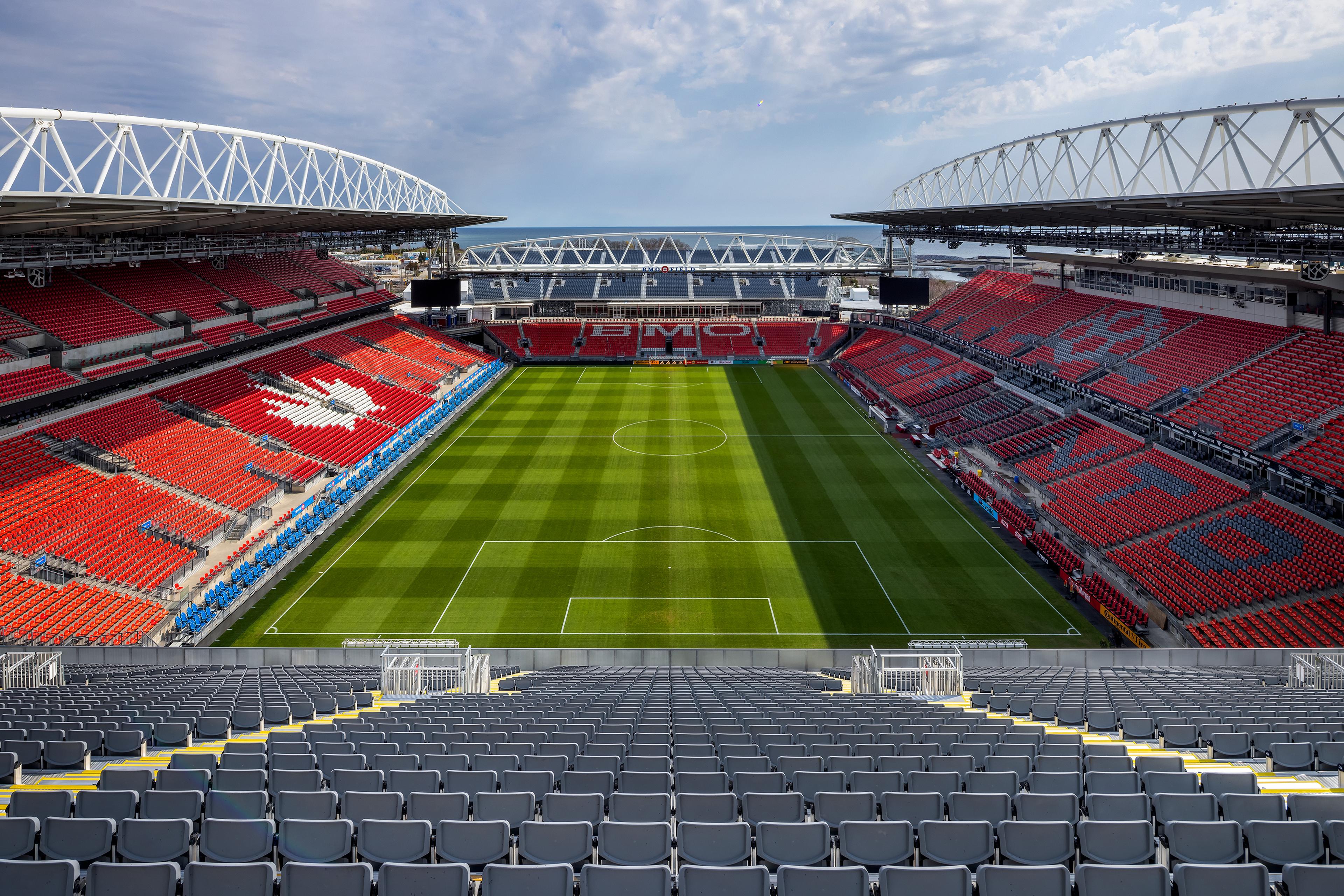 A sports stadium with a green field.