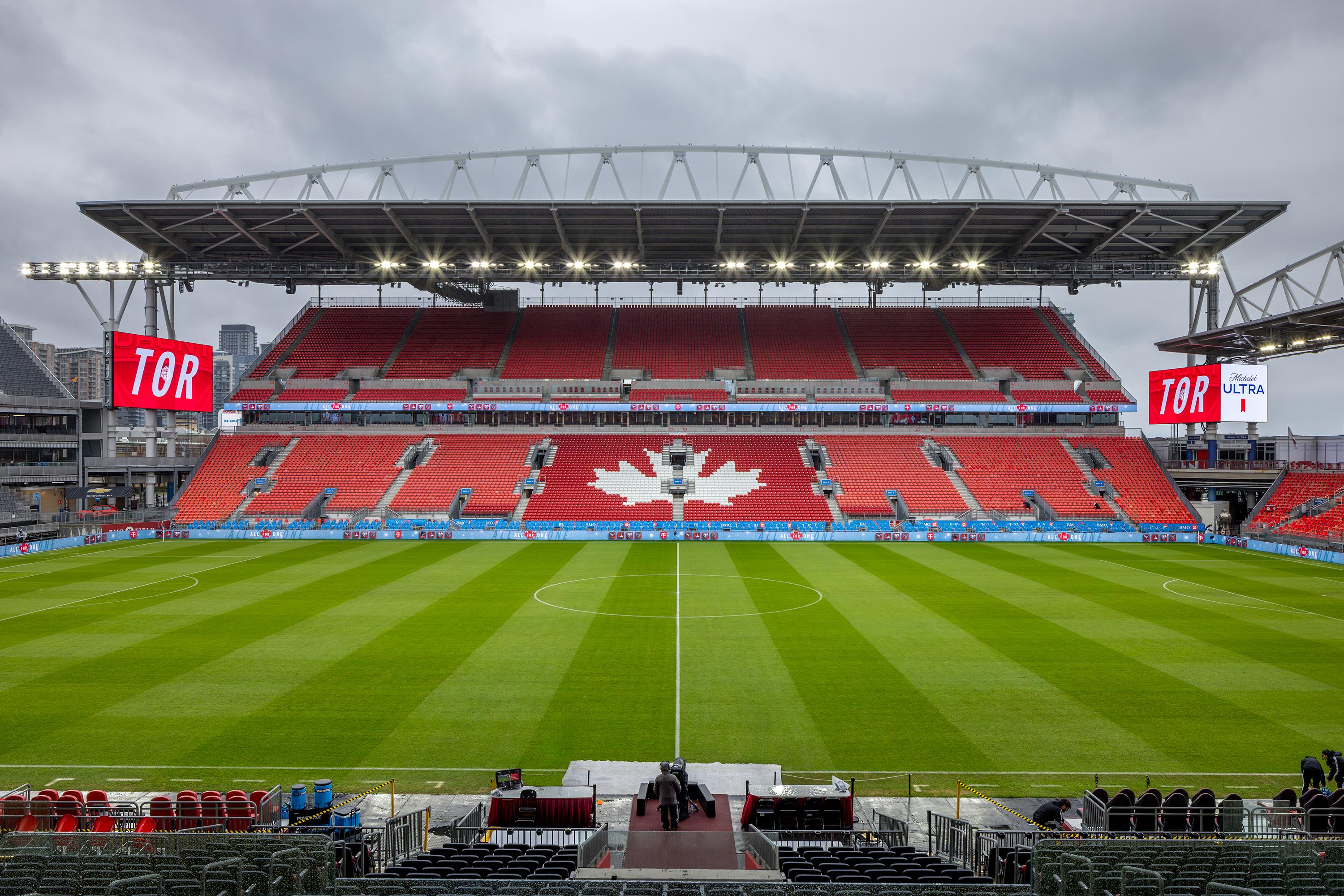 A sports stadium with a field and a field with a large crowd.