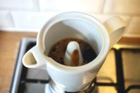 Coffee pouring out the funnel inside the Legnoart moka pot.