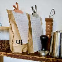 Two bags of coffee on a shelf with individual tasting cards attached to each bag with a clip.