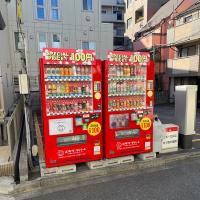 Two red vending machines by a parking lot in Tokyo