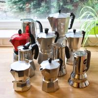 10 different moka pot grouped together on a wooden kitchen top