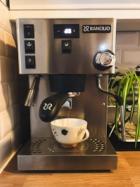 A blocky steel espresso machine making an espresso into a coffee cup