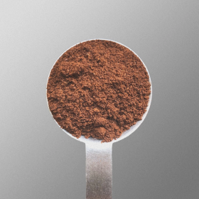 A scoop of ground coffee on a silver background