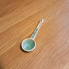 A ceramic spoon with green glaze patches