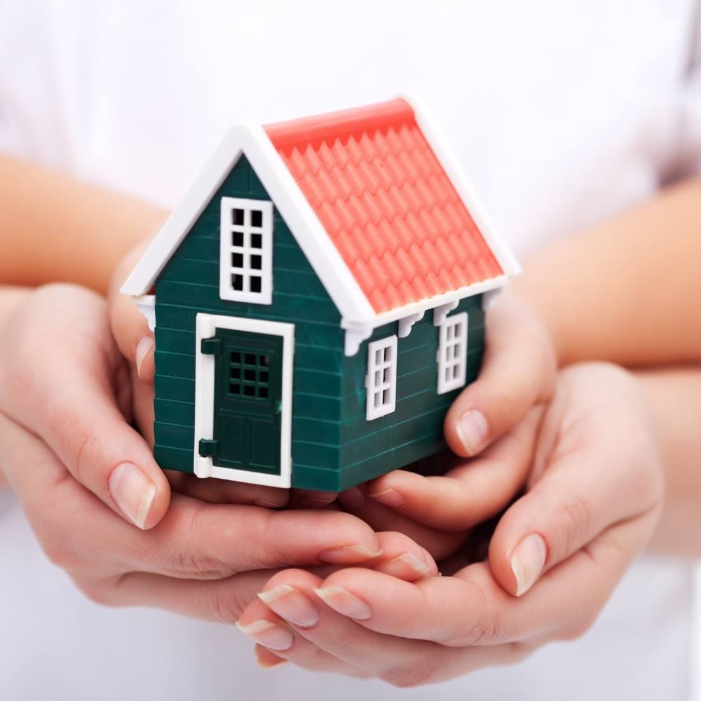 Hands holding a model home representing the journey to home ownership with Homesquare.