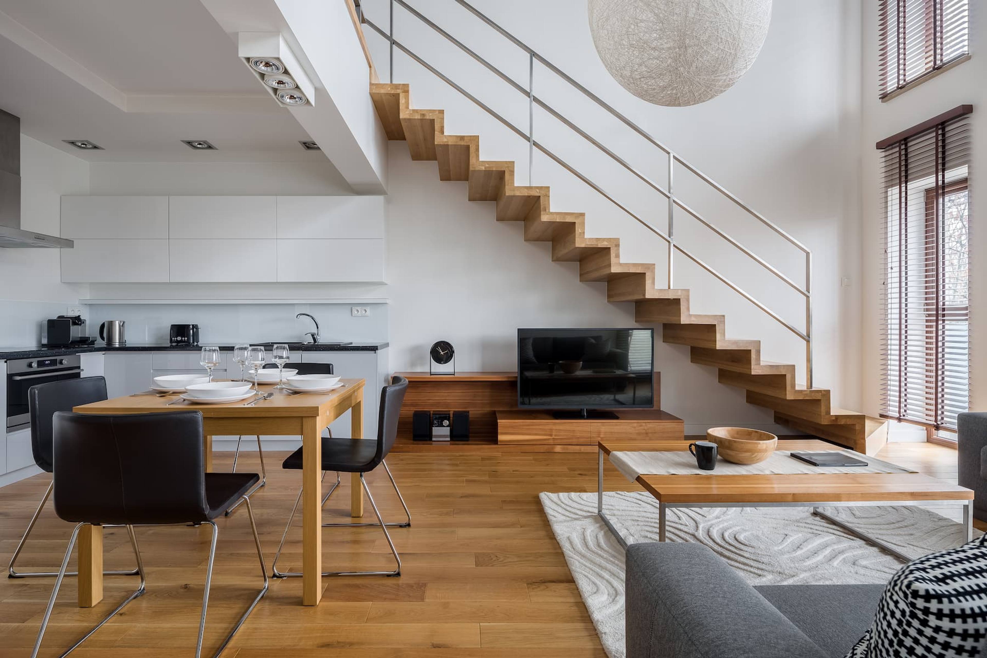 Modern open plan living, dining and kitchen with floating timber staircase.
