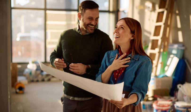 Happy couple reviewing home plans during the construction of their new home