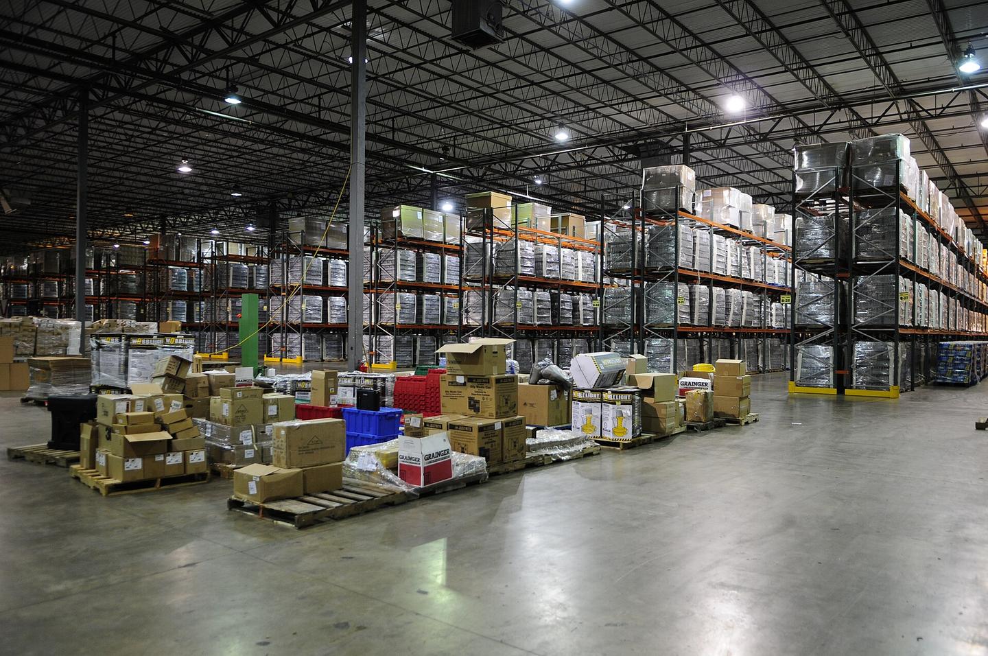 Almacén con tarimas de mercancía y racks altos