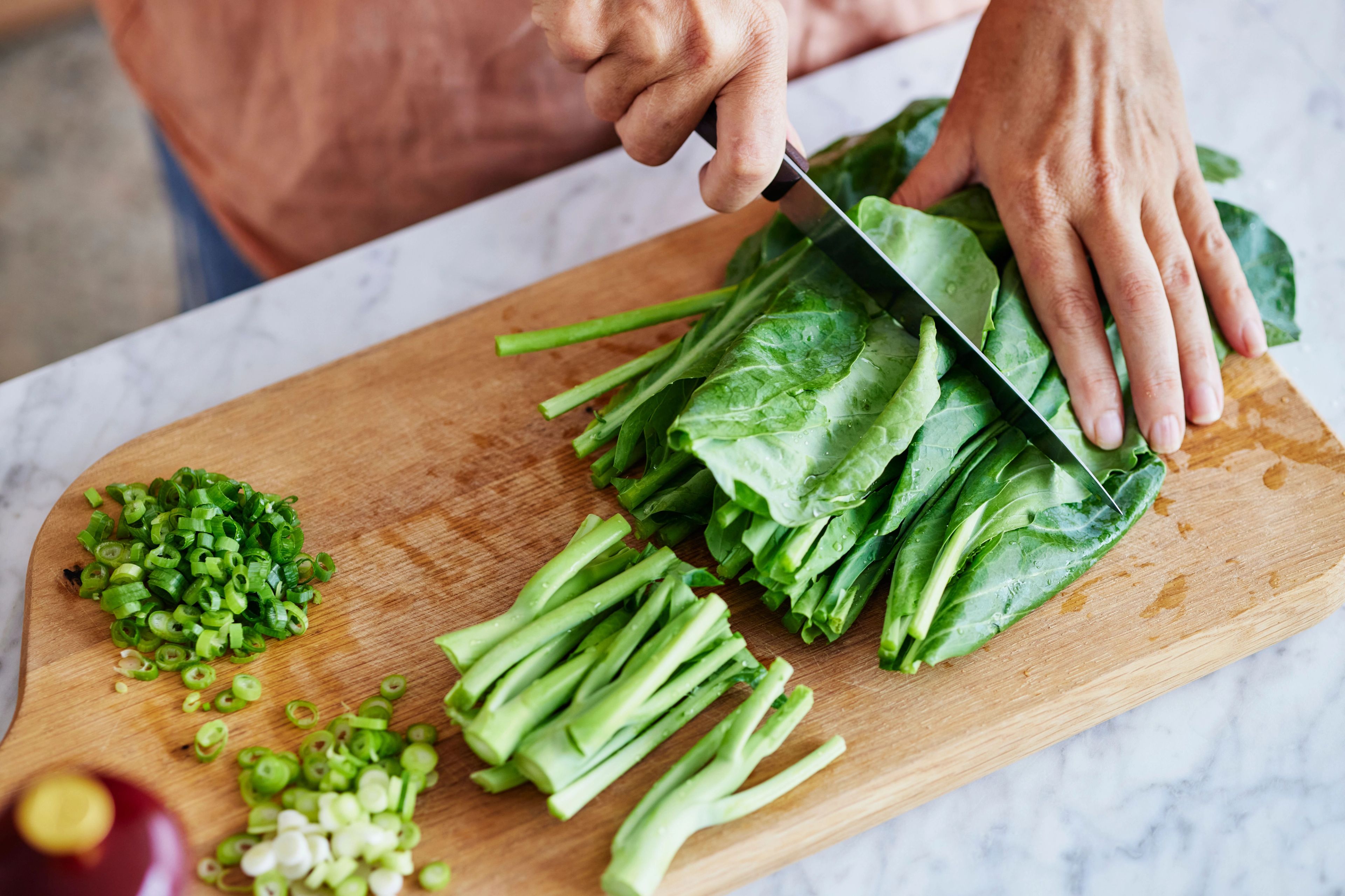 fresh gai lan from quitelike being prepared on kitchen bench