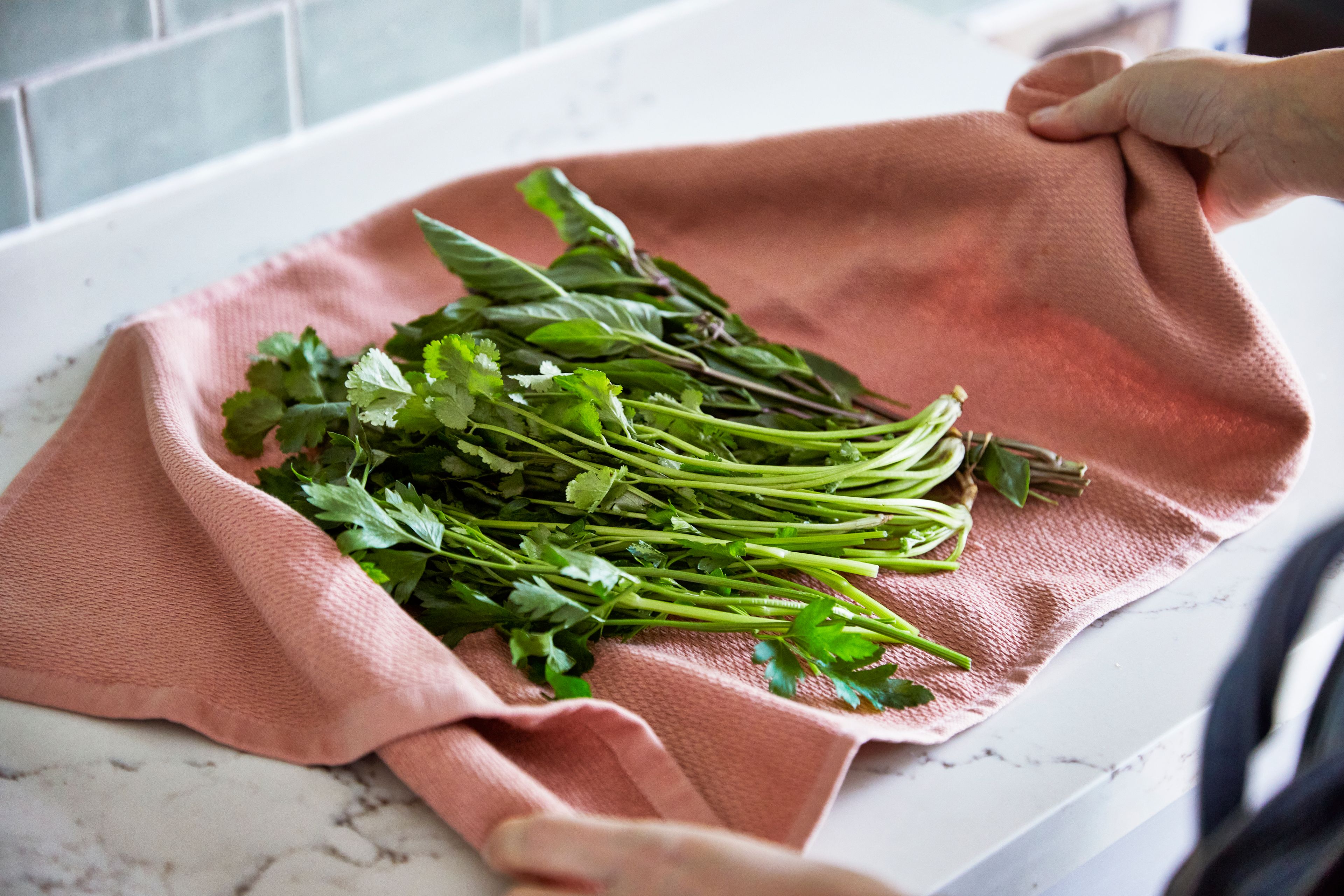 fresh bunch of herbs being dried on tea towel