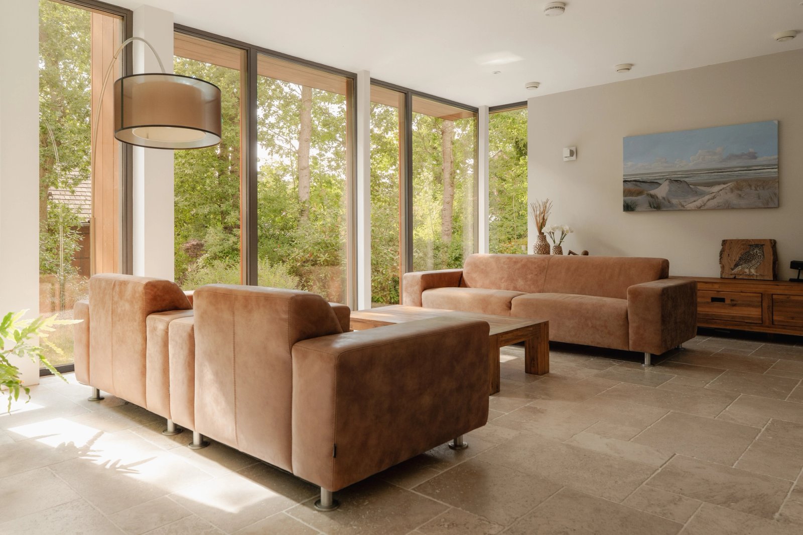 Lichte leefruimte met panoramisch uitzicht en rustige zichtlijnen in villa Hogenolweg Groet