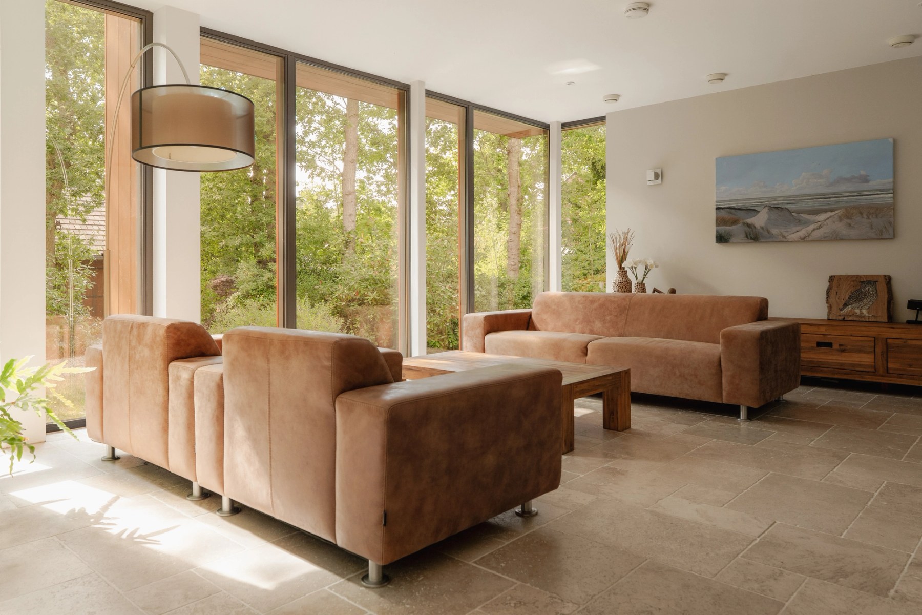 Zitkamer met glazen wanden rondom en uitzicht op de tuin