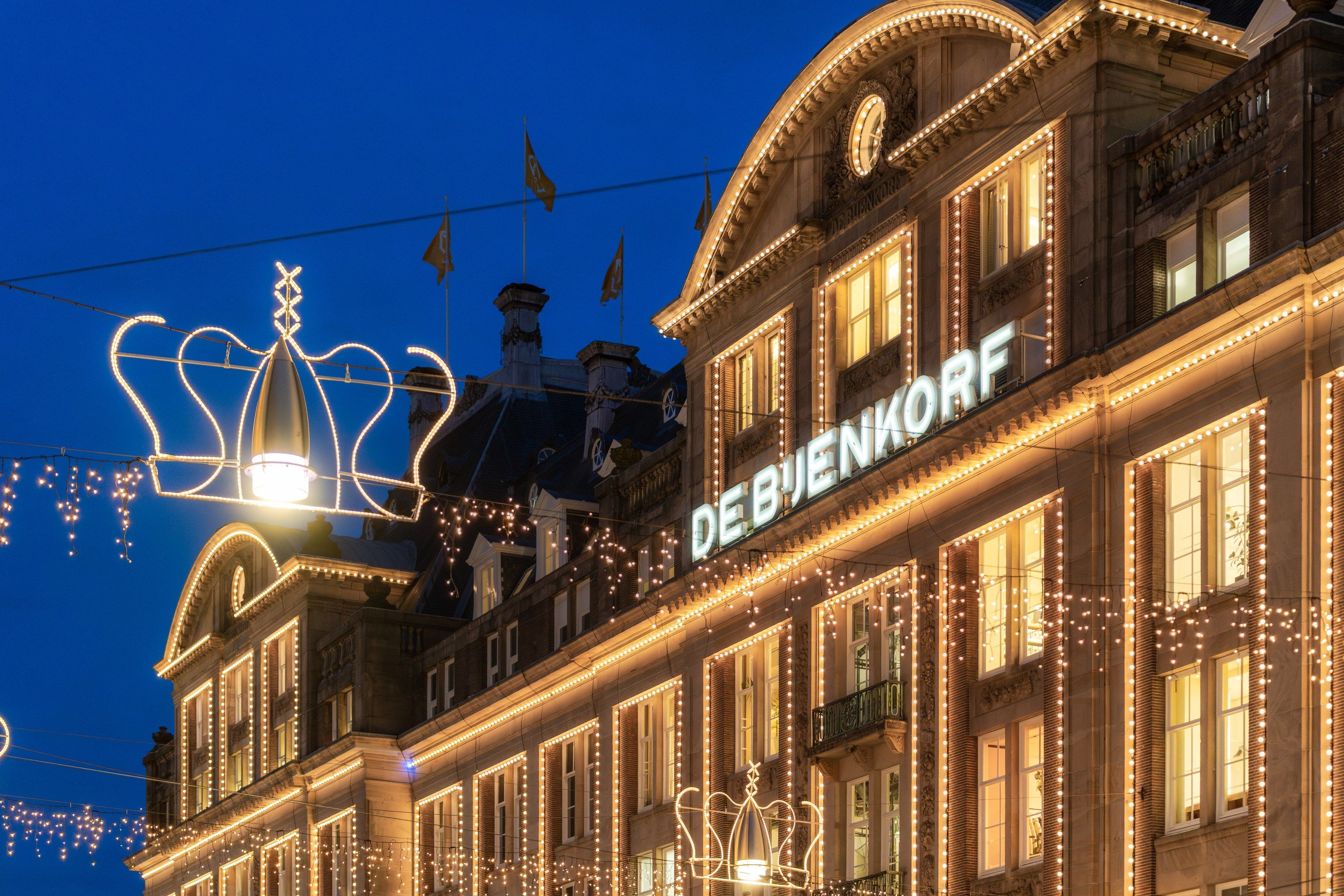 De Bijenkorf tijdens het blauwe uur, met een verlichte kroon