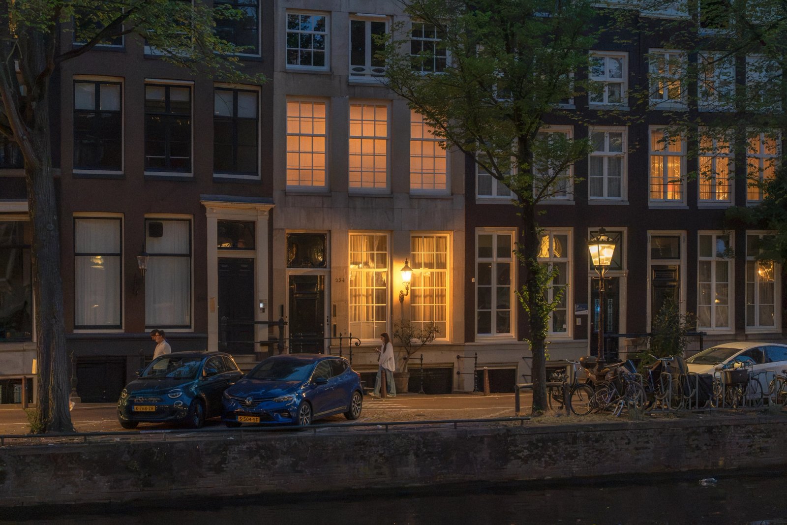 Warm verlichte salon met uitzicht op de Amsterdamse avondlucht