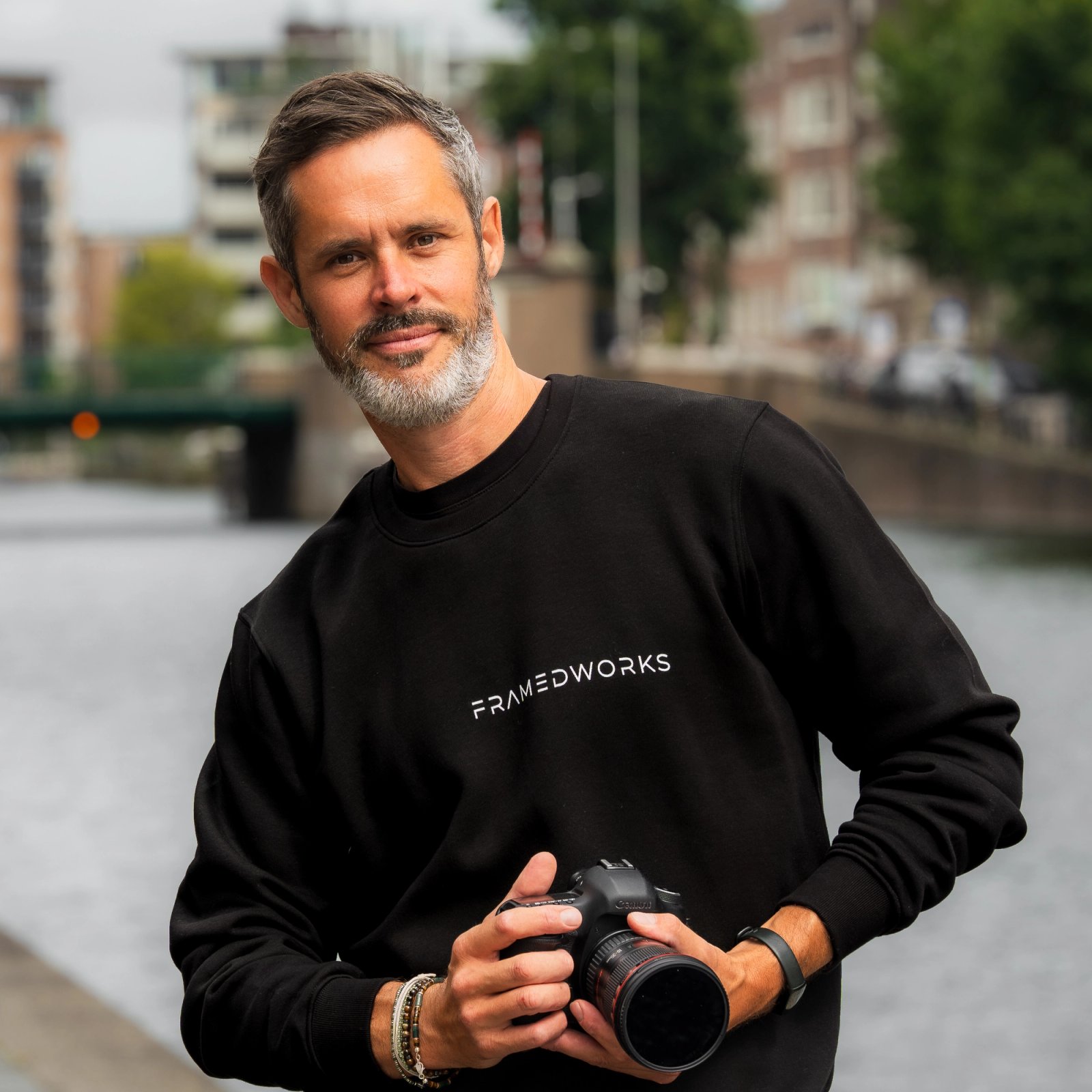 Eddie van Framedworks met camera aan een Amsterdamse gracht