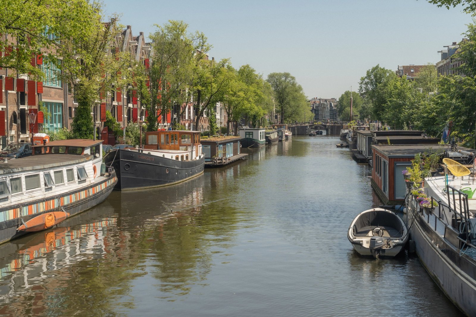 Woonboten langs een Amsterdamse gracht op een zonnige dag