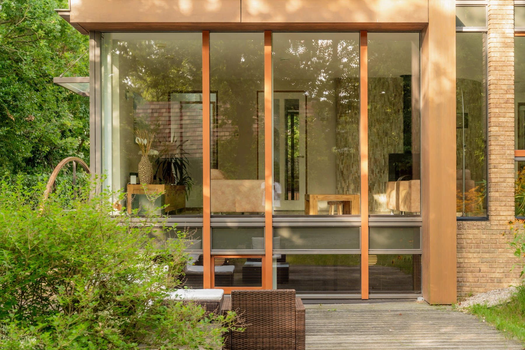 Glazen achtergevel van de villa, gezien vanuit de tuin