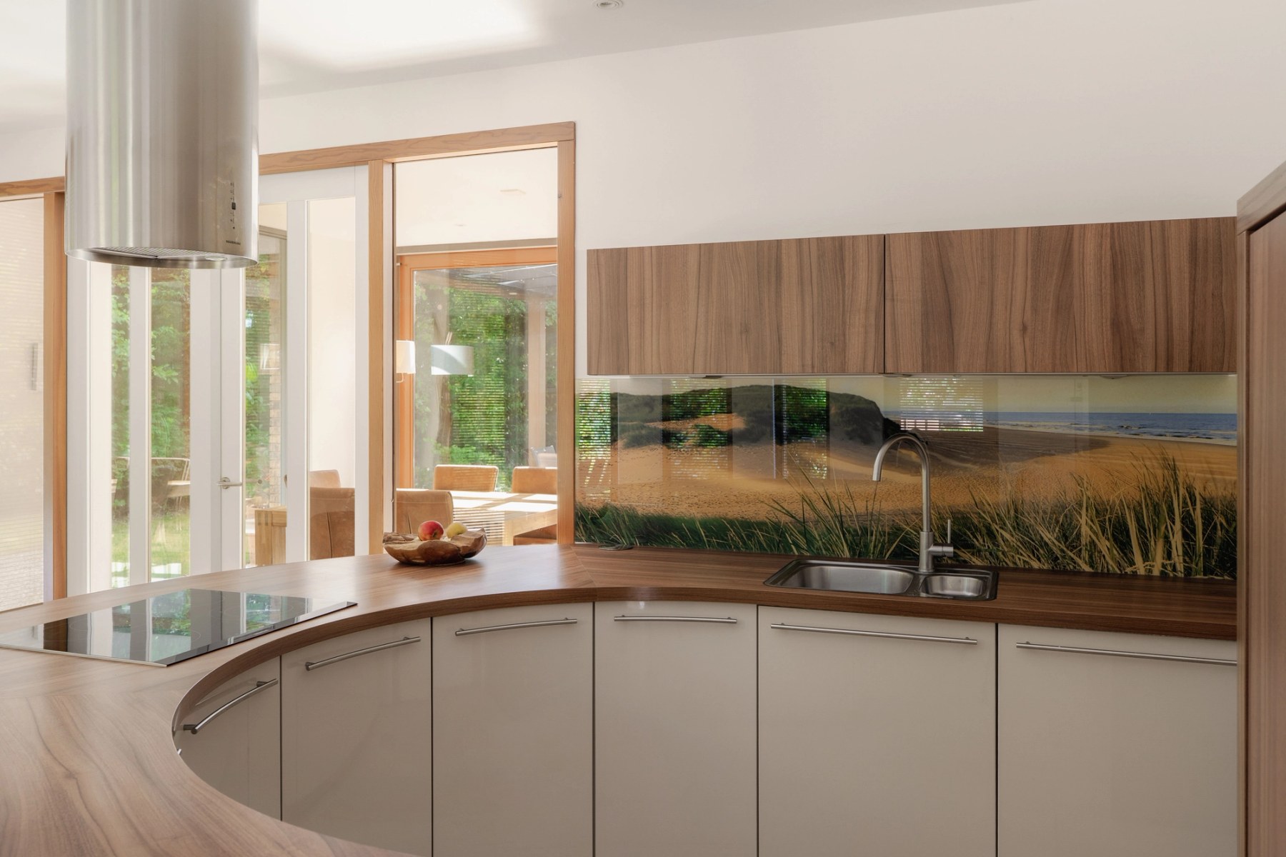 Rond kookeiland met houten werkblad en zicht op de tuin