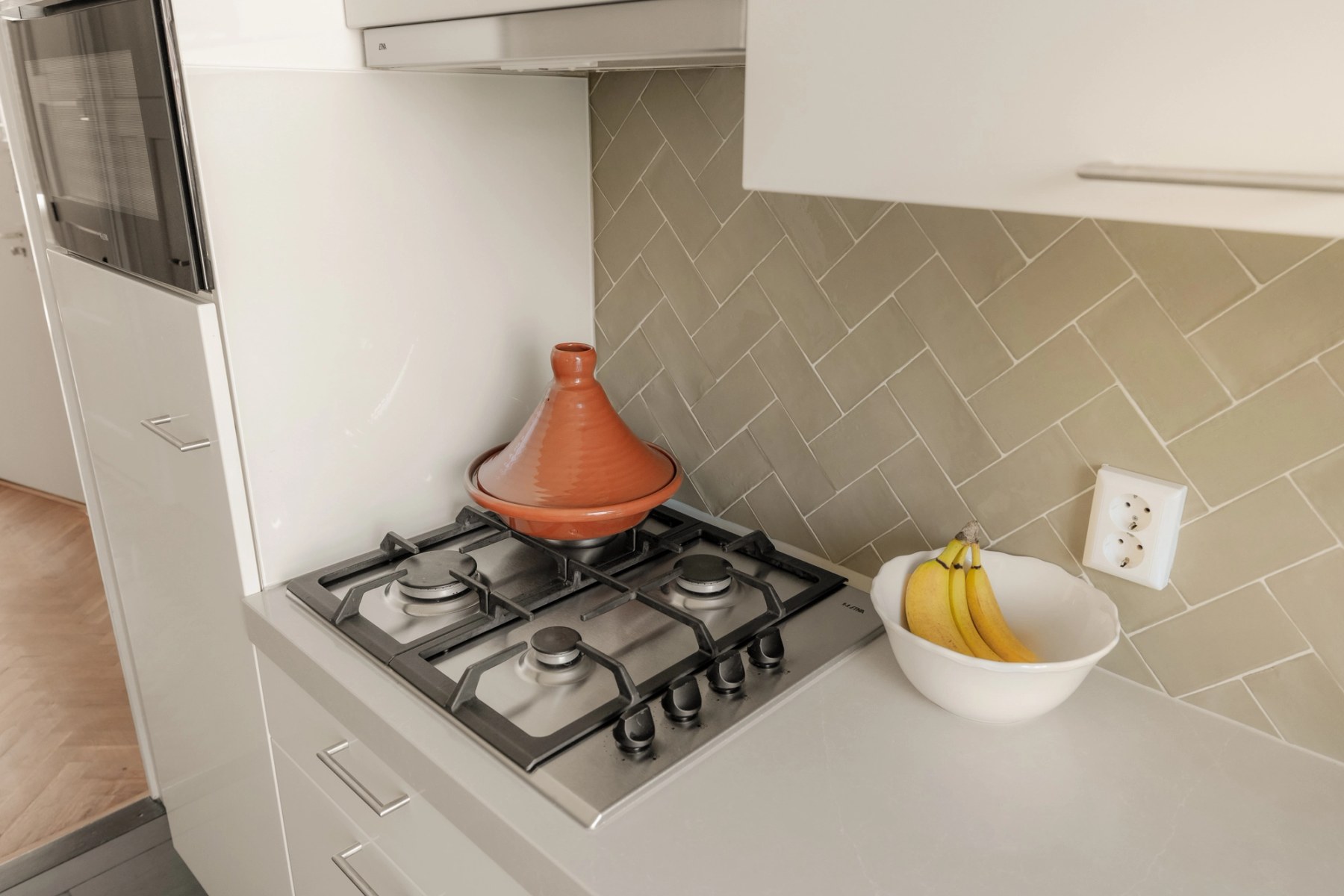 Detail van de keuken met gasfornuis, tajine en tegelwand in visgraatpatroon