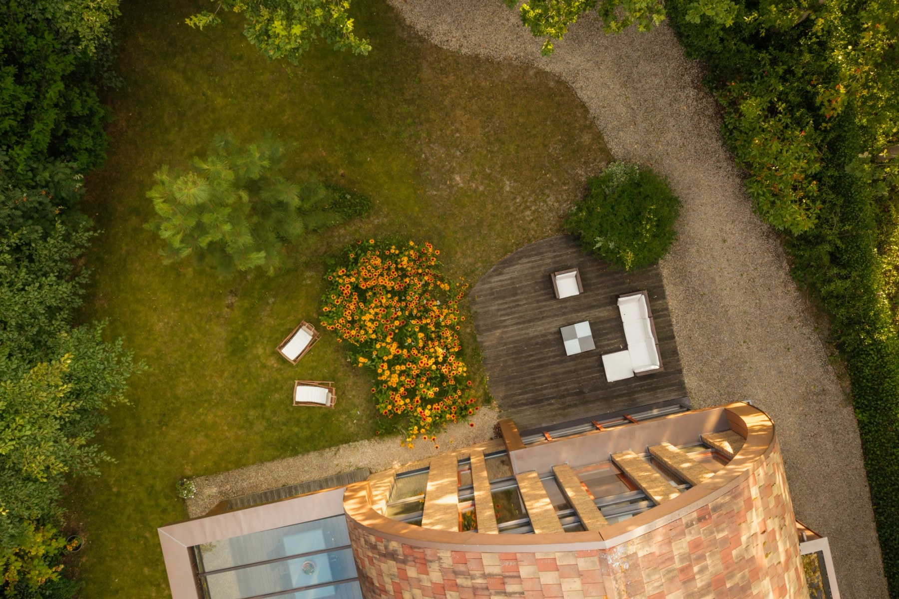 Bovenaanzicht van de tuin, het terras en de dakrand van de villa