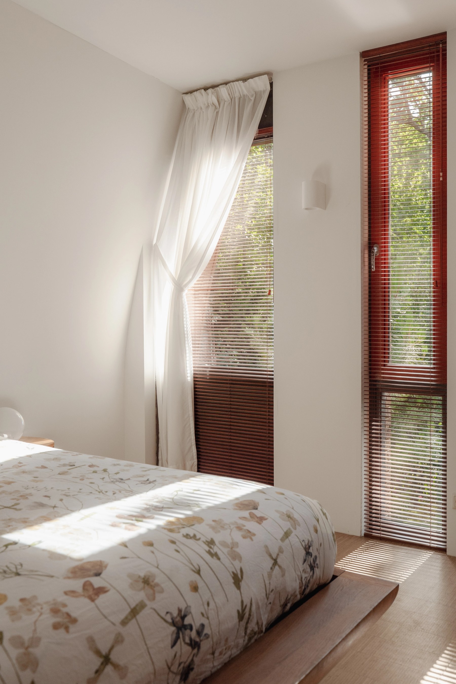 Slaapkamer met vitrage en zonlicht op het bed