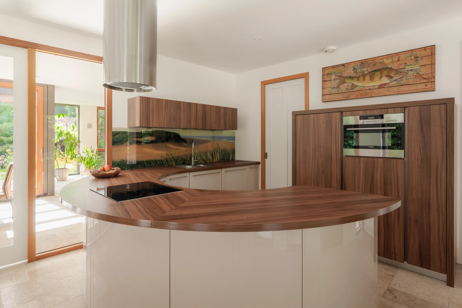 Keuken met rond kookeiland en houten kastenwand