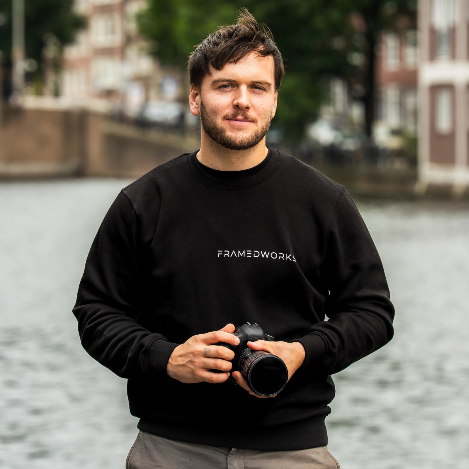 Bryan van Framedworks met camera aan het water in Amsterdam