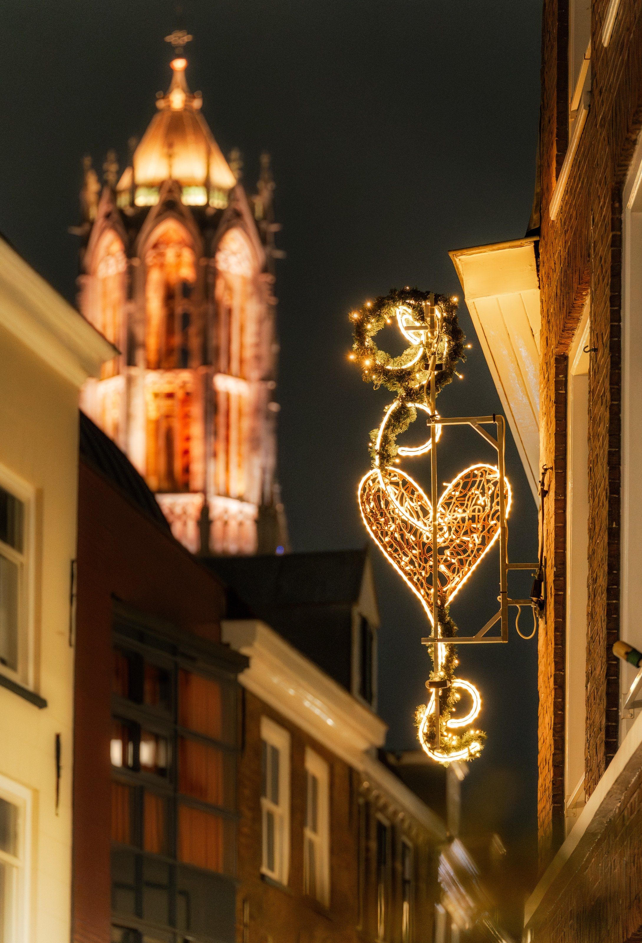 Verlicht hart in een smalle straat, met de Domtoren erachter