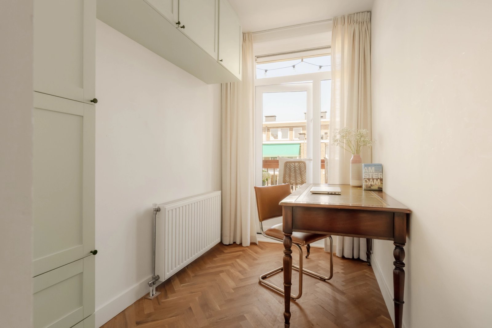 Warme woonkamer met houten vloer en doordachte meubelopstelling in Amsterdam
