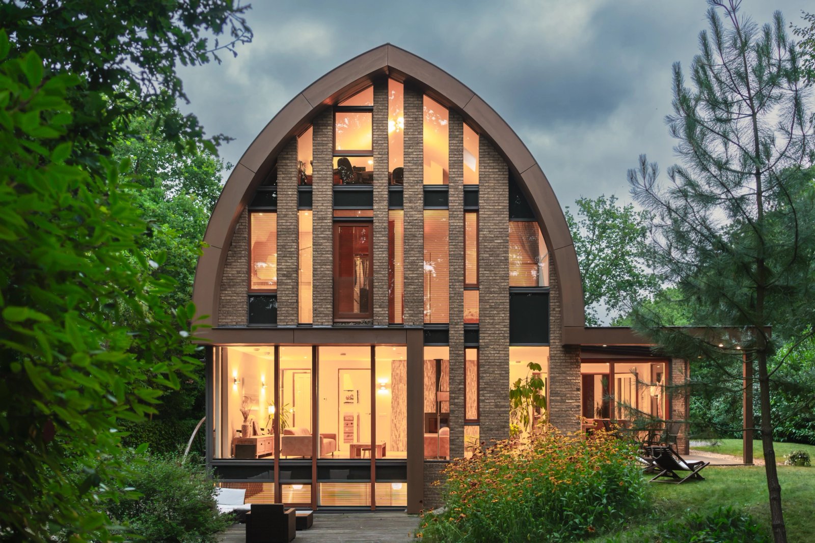 Cinematische avondopname van villa Hogenolweg met verlichte raampartijen