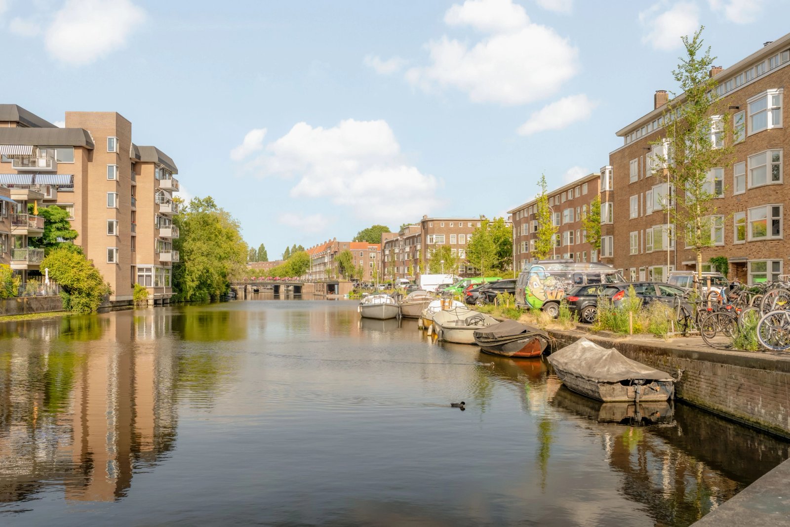 Gracht in Amsterdam met appartementengebouwen en woonboten langs de kade