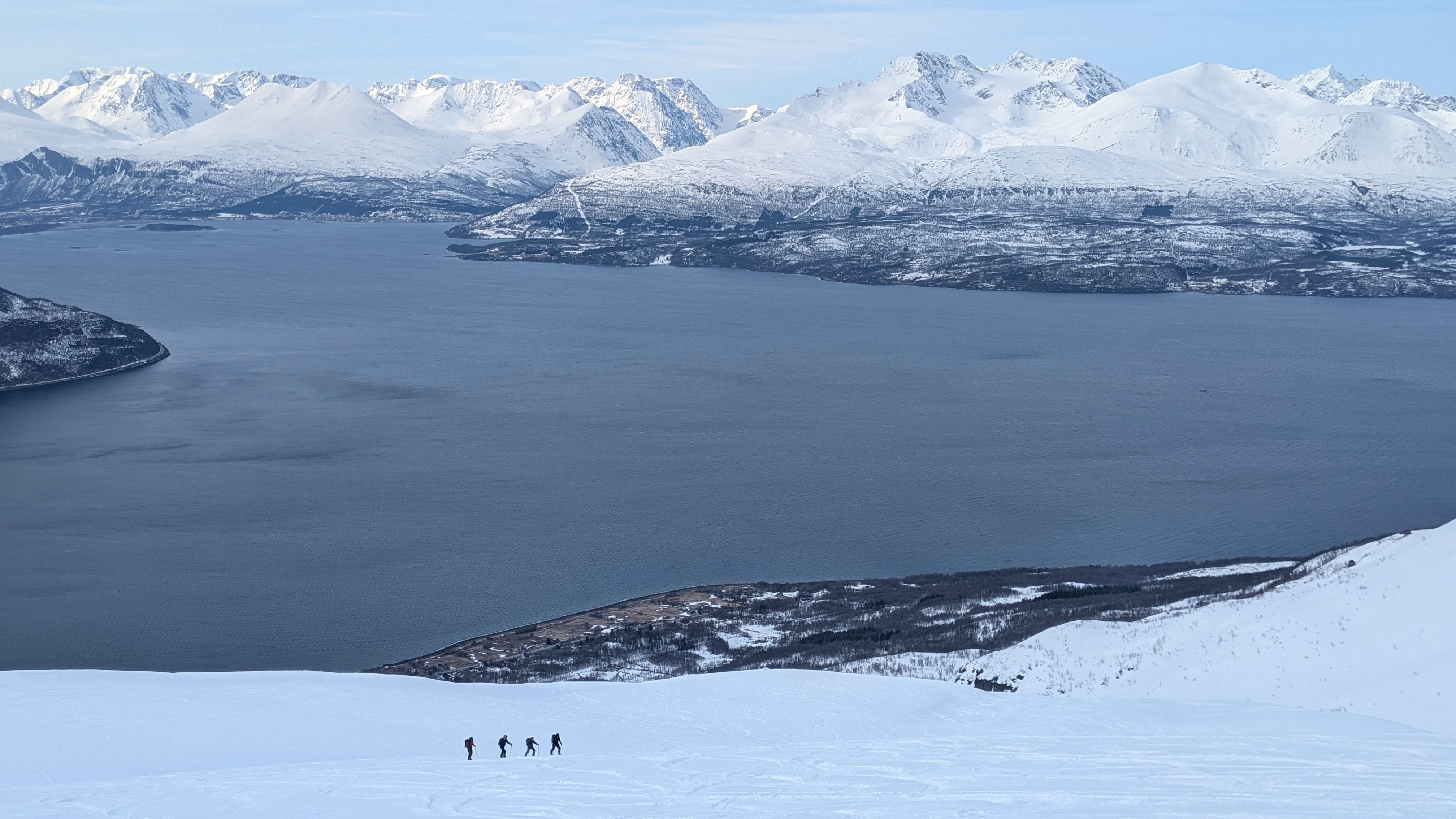 Ski de rando au dessus du fjords avec les Alpes de Lyngen en fond.