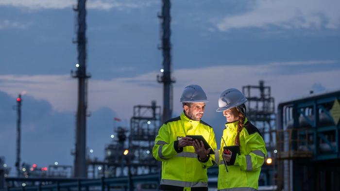 Mann og kvinner i energibransjen som vurderer noe på en skjerm.
