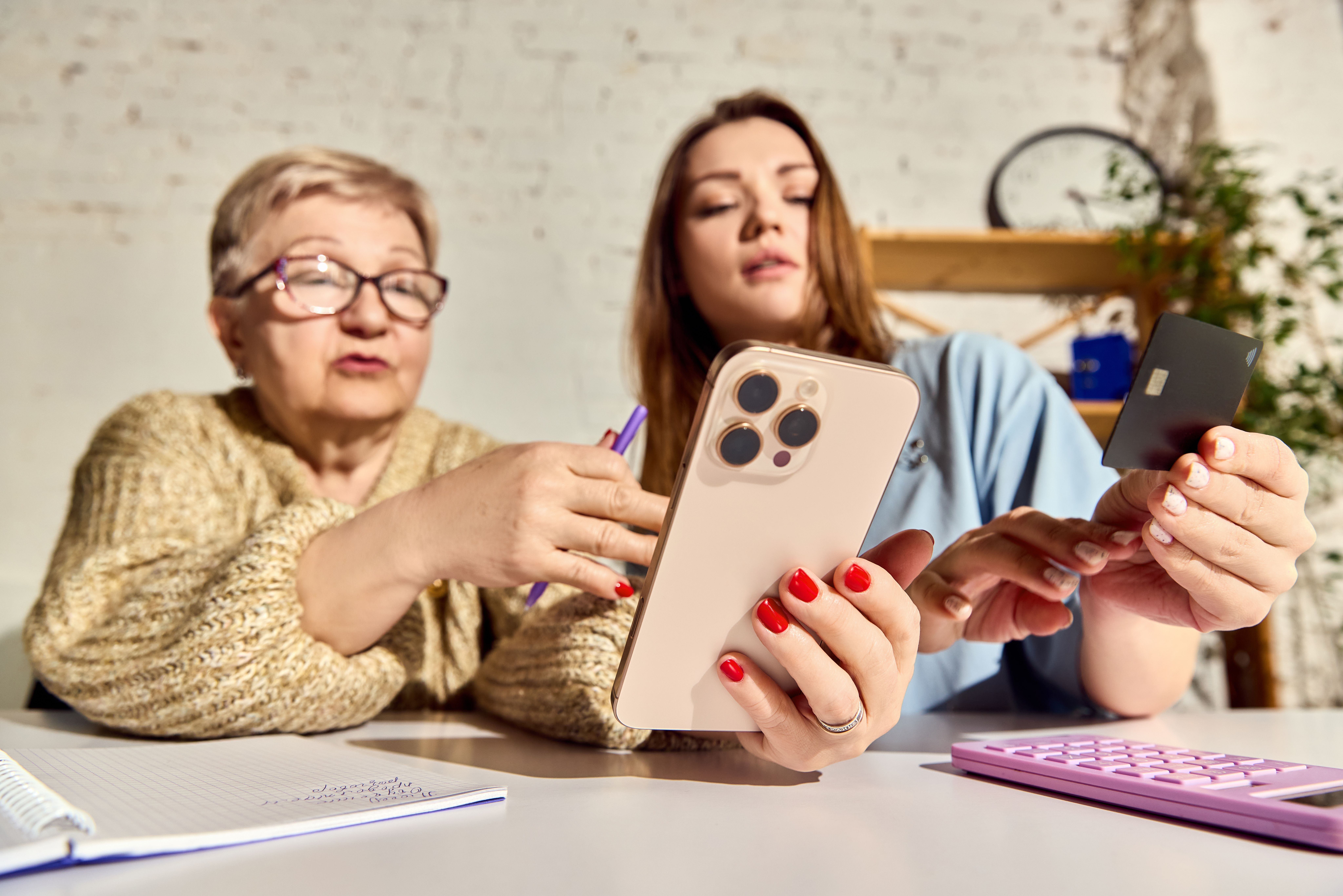 En bestemor og et barnebarn som ser på telefonen