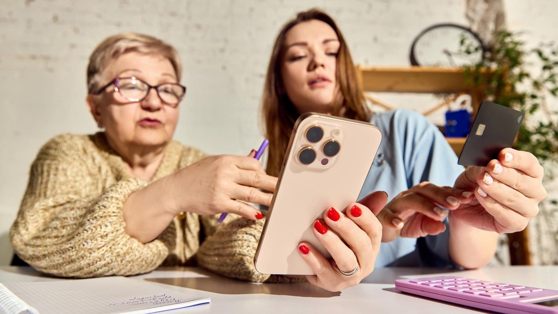 En bestemor og et barnebarn som ser på telefonen