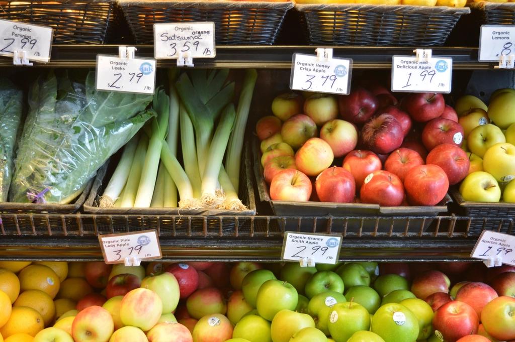 Marktstand mit Obst und Gemüse und handgeschriebenen Preisschildern