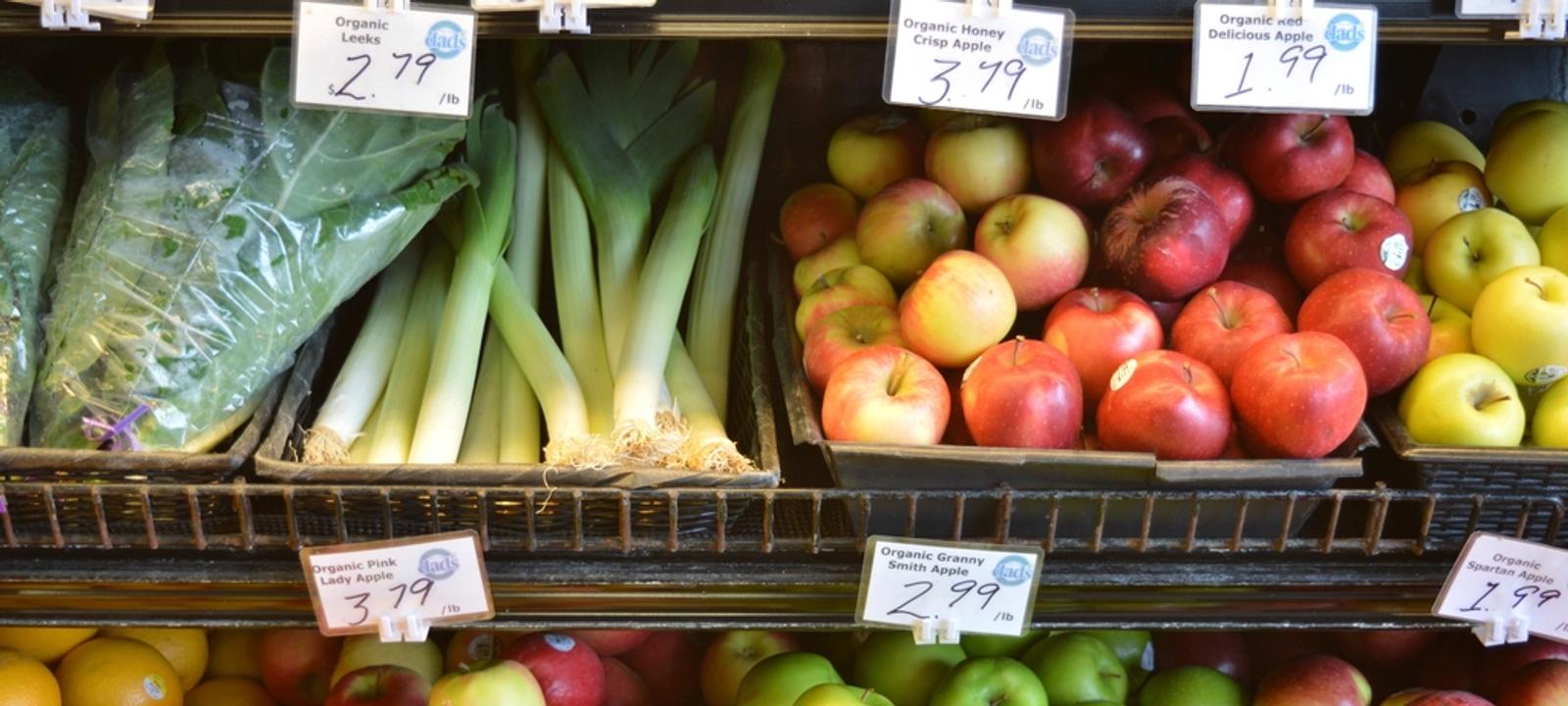 Marktstand mit Obst und Gemüse und handgeschriebenen Preisschildern