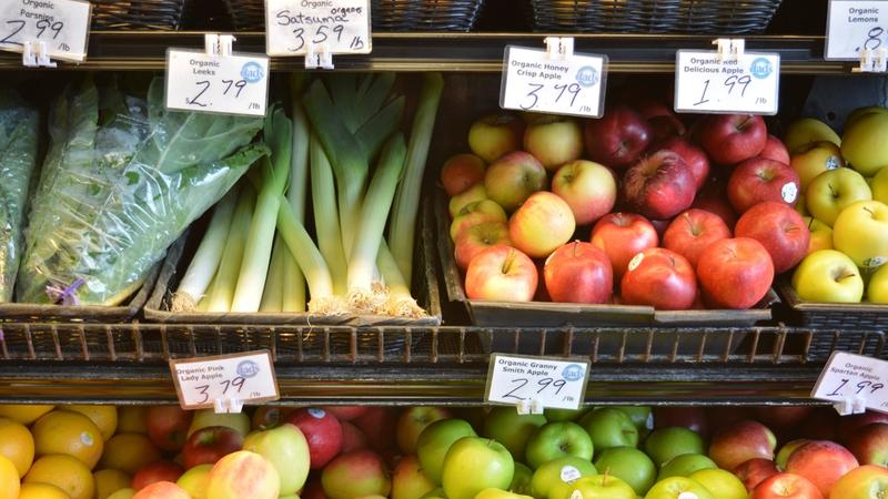 Marktstand mit Obst und Gemüse und handgeschriebenen Preisschildern