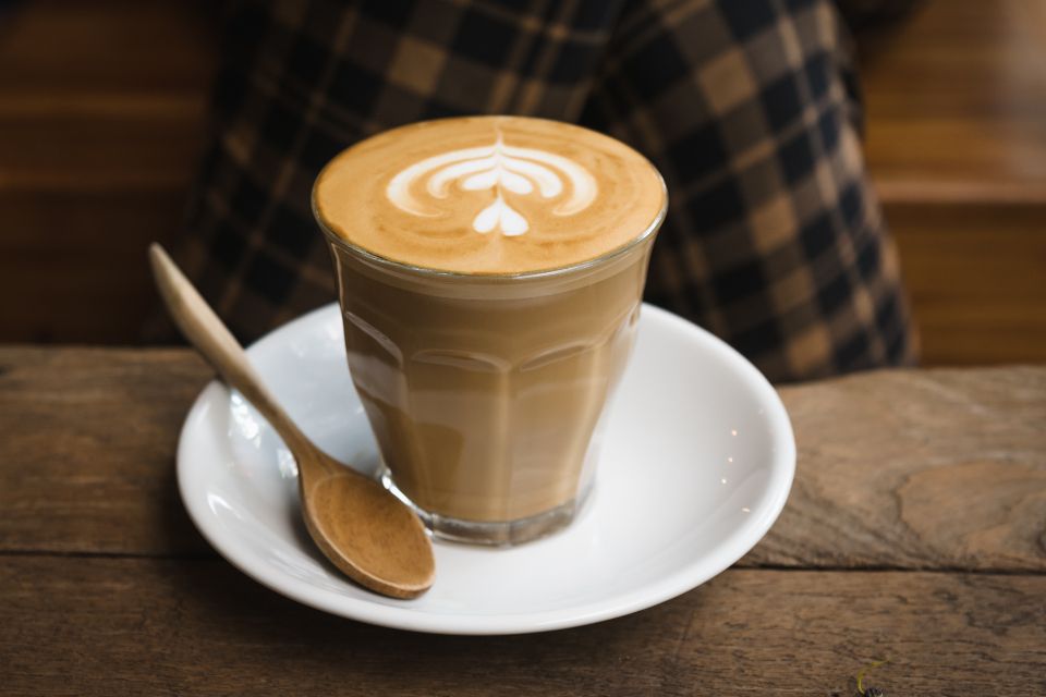 Cappuccino mit Milchschaum-Muster auf einem Holztisch