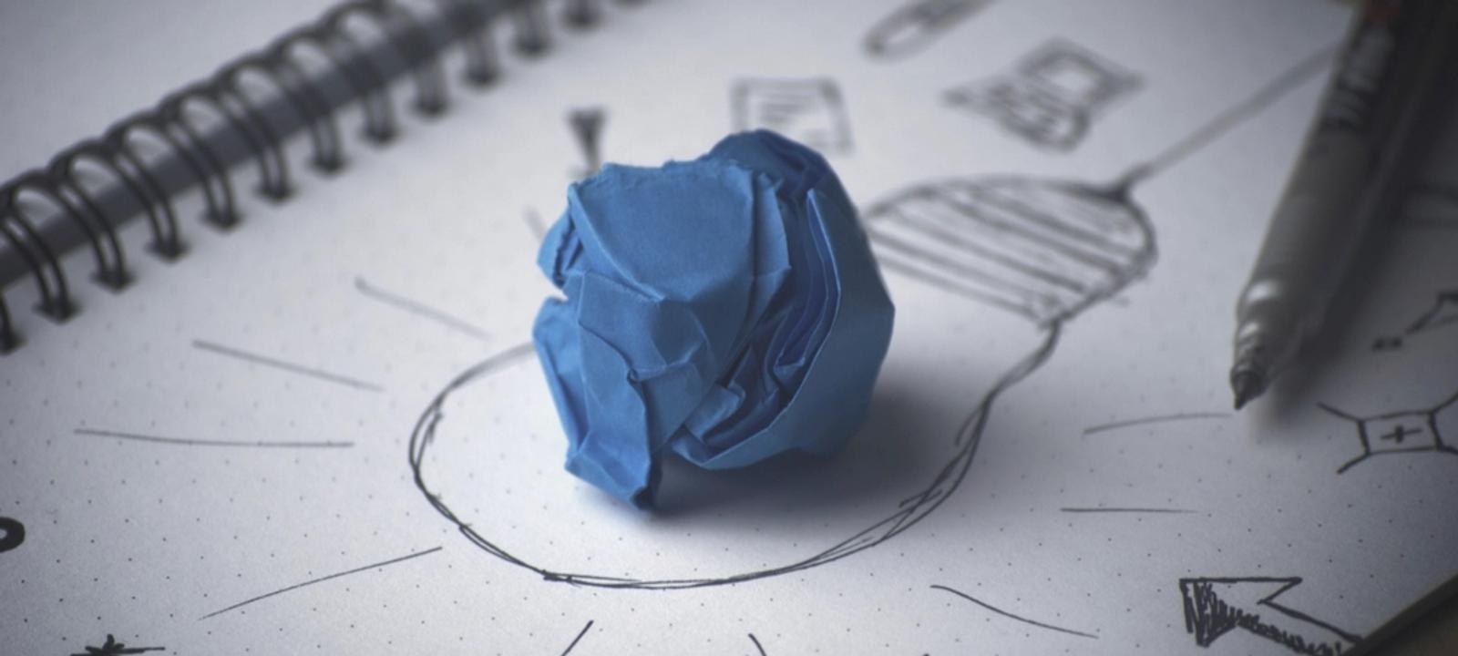 Zerknülltes blaues Papier auf einer Skizze in einem Notizbuch