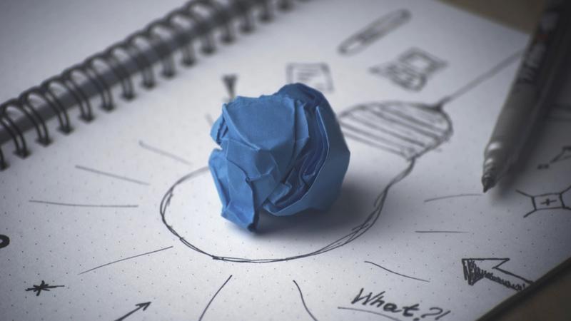 Zerknülltes blaues Papier auf einer Skizze in einem Notizbuch