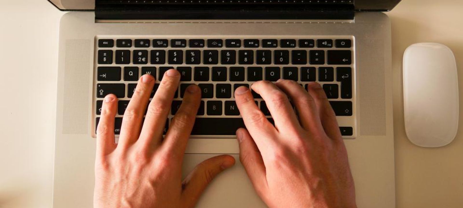 Hände tippen auf der Tastatur eines Laptops