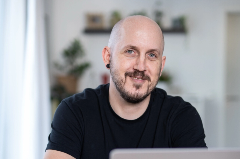 Benny Schey lächelnd am Laptop