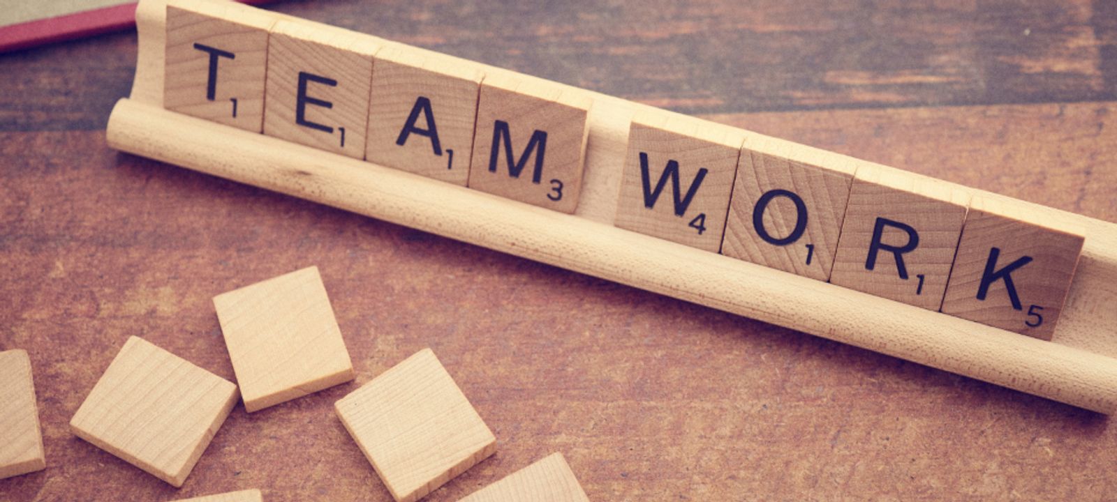Scrabble-Steine bilden die Worte TEAM WORK