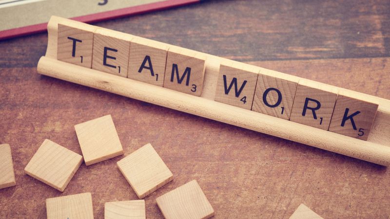 Scrabble-Steine bilden die Worte TEAM WORK
