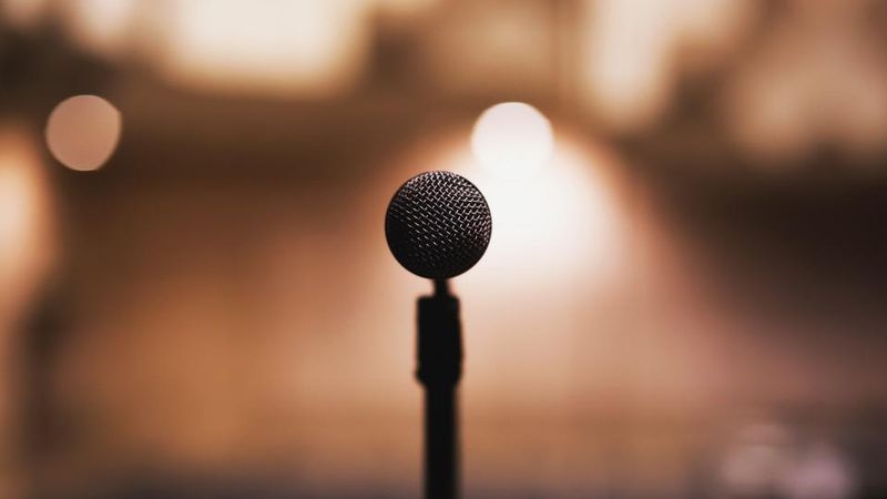 Mikrofon auf einer Bühne vor warmem, unscharfem Licht